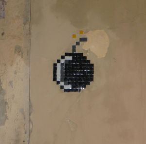 Invader-inspired black mosaic cartoon bomb in Barcelona